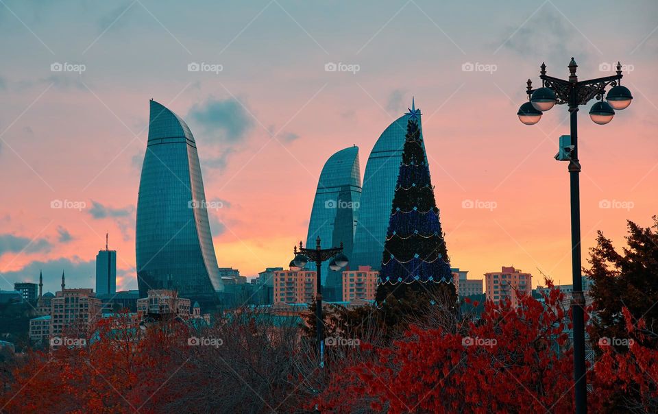 Baku, Azerbaijan - December 22, 2017: Baku skyline, flame towers and Christmas tree at sunset on December evening just before Christmas.
