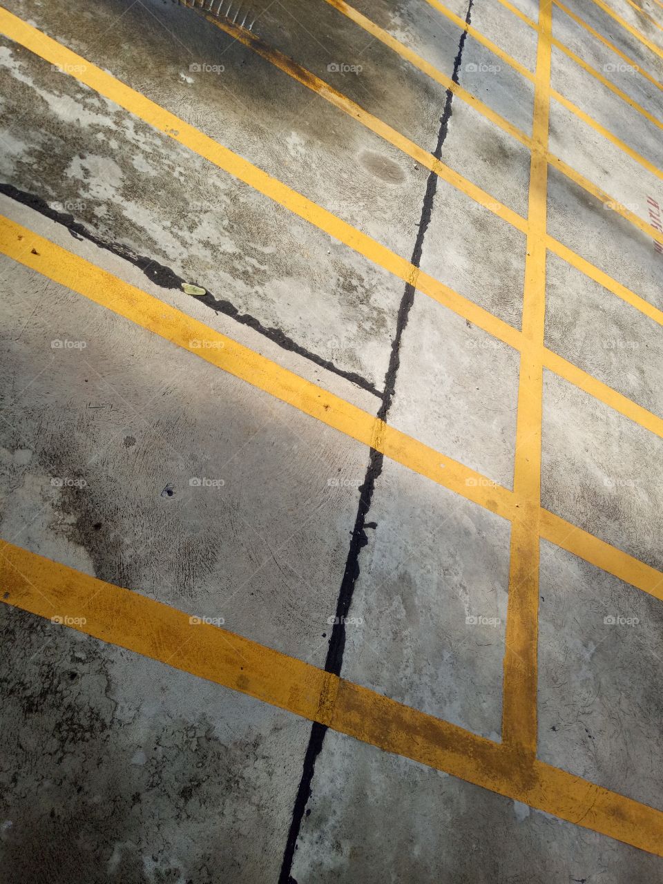 Full frame shot of parking lot. Yellow line mark on the ground.