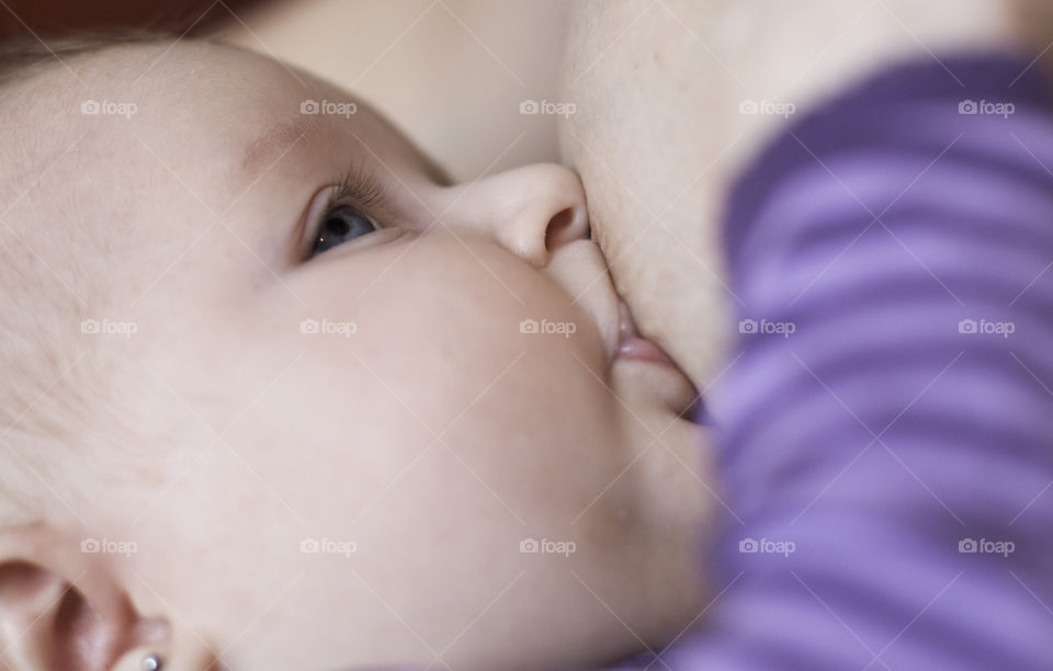 Close-up of mother breastfeeding her baby