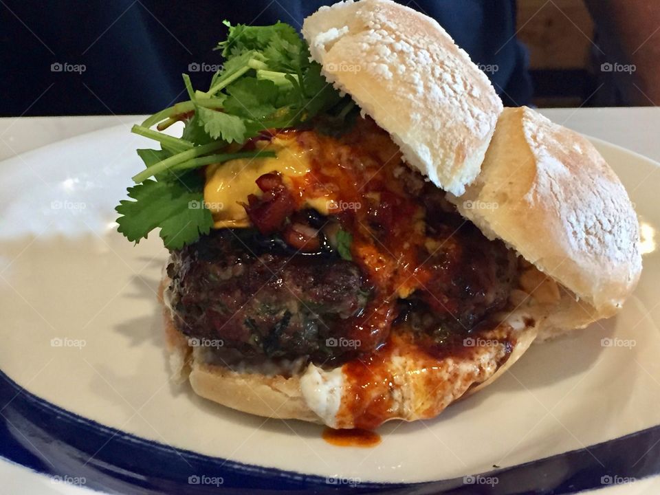 Lamb burger served on a Portuguese roll with piri piri sauce