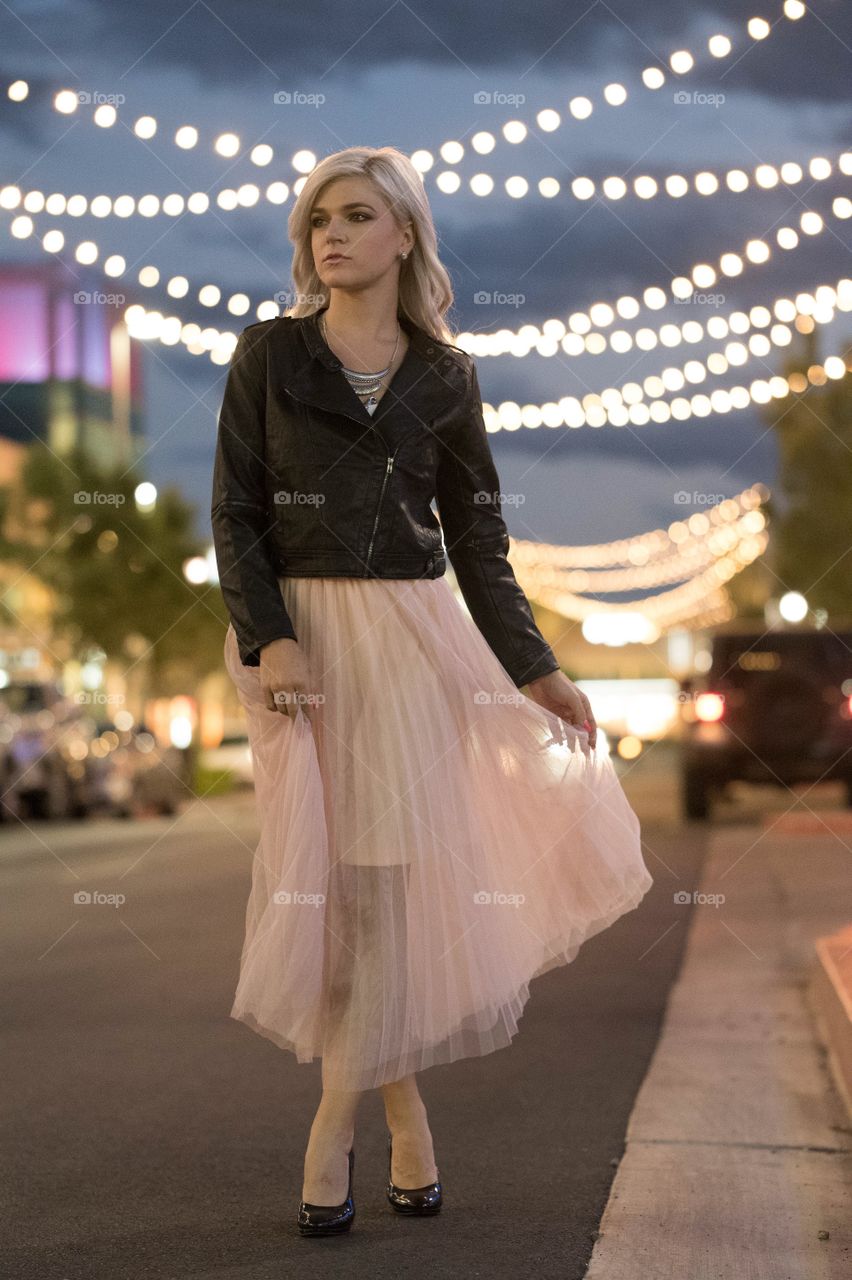 Outdoor girl pink skirt leather jacket lights walking 
