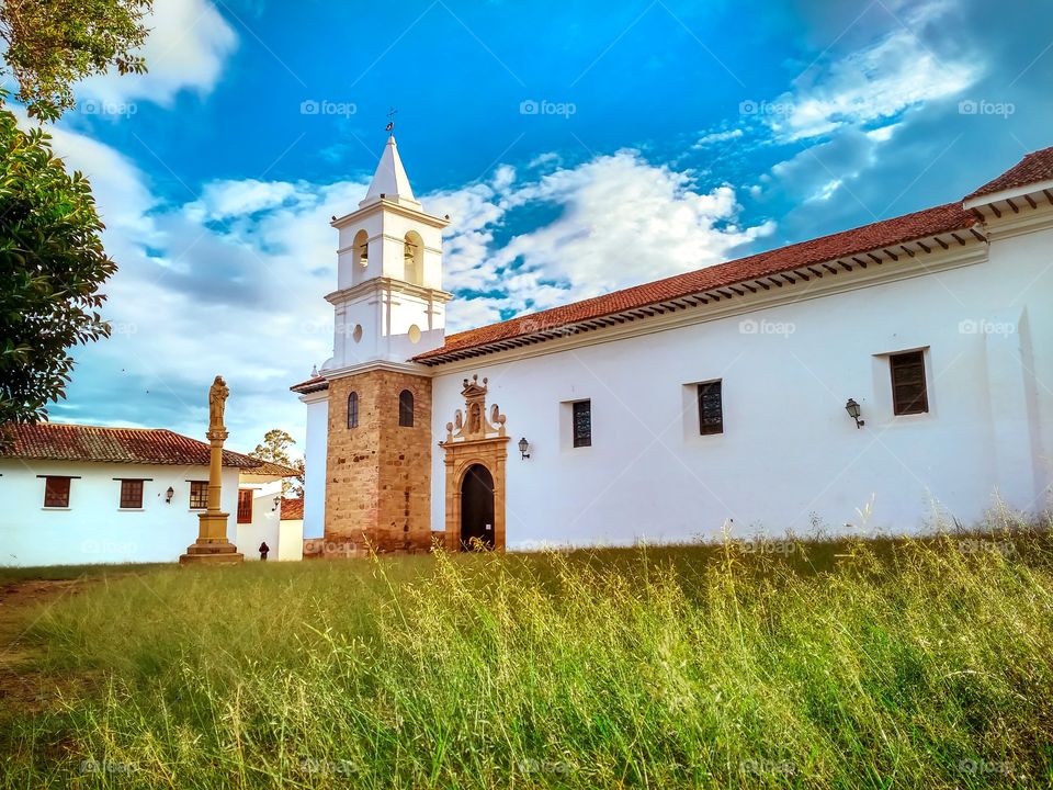 Villa de Leyva - Iglesia católica Nuestra señora del Carmen en Boyacá, Colombia. Catholic Church of Our Lady of Carmen. Sky blue, creen forest. Horizontal