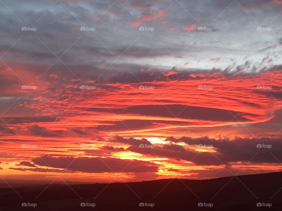 Mesmerizing Moments: An Exceptional Sunset in Telemcen; This photo captures a captivating moment of sunset in telemcen, Algeria. The sky is ablaze with vibrant warm colors, ranging from orange and red to purple and violet hues,