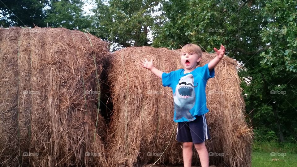 Boy by hay bale