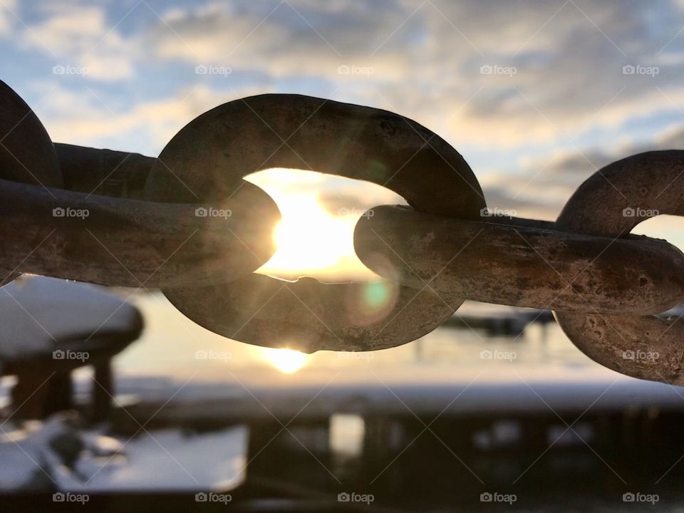 Sun shining through a rustic chain