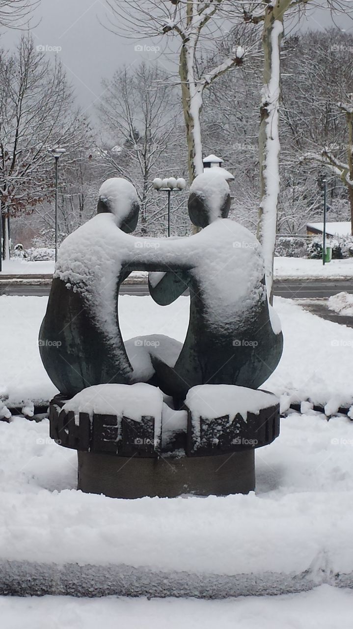 Statue zweier Freunde ziert einen Brunnen.