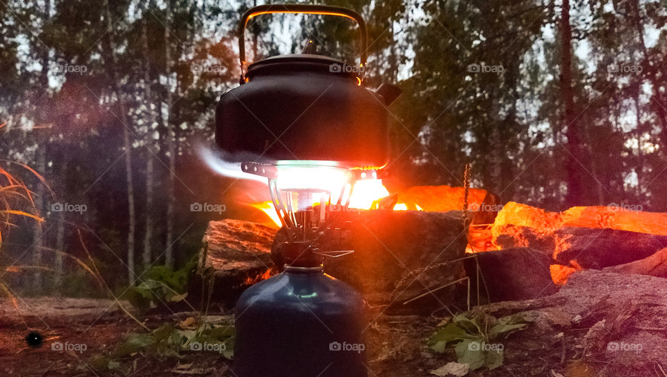 kettle on the burner on the background of the fire