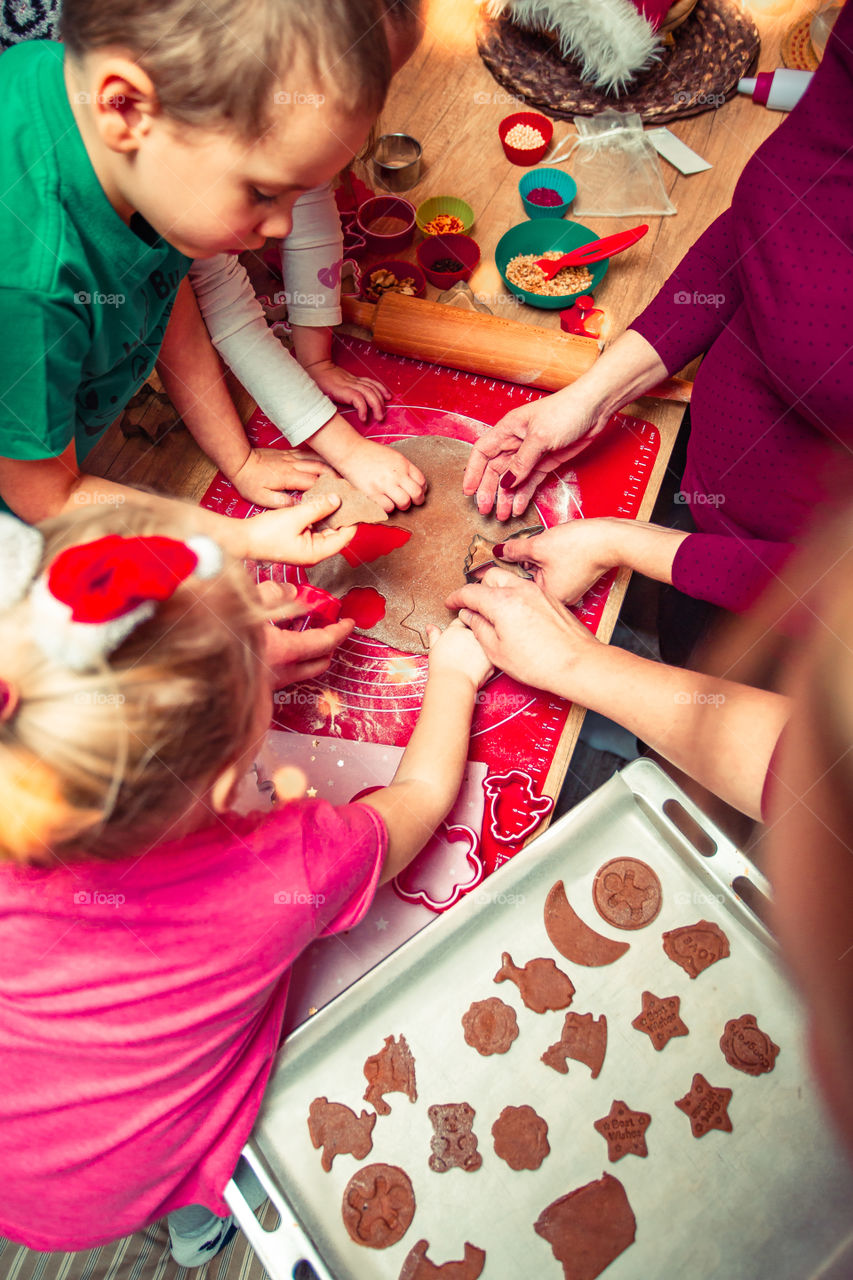 Baking Christmas cookies. Christmas gingerbread cookies in many shapes decorated with colorful frosting, sprinkle, icing, chocolate coating, toppers, put on table. Baking traditional cookies. Family celebrating Christmas. Baking at home
