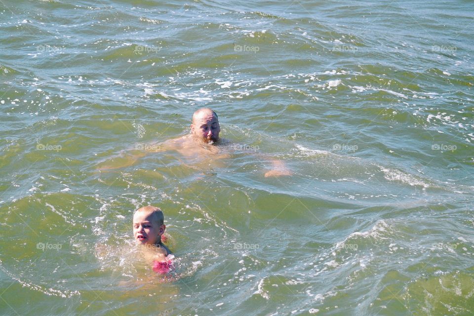 Father and son taking a swim in the ocean