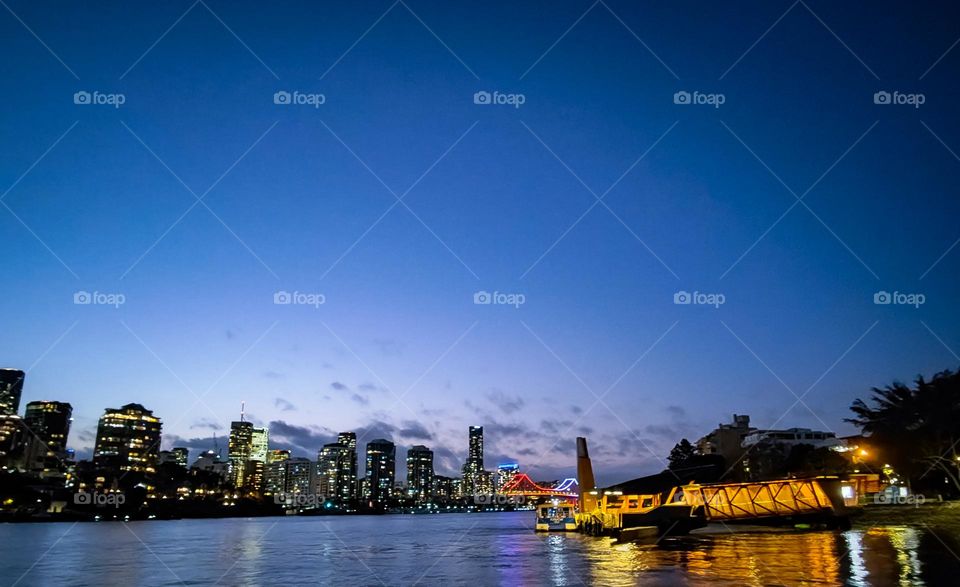 City Cat ferry picking up commuters from the Sydney street terminal at dusk in Brisbane, Australia.