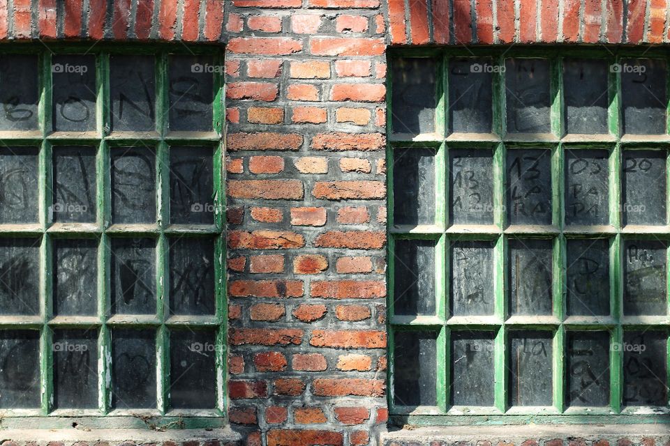 Two windows in an old brick wall