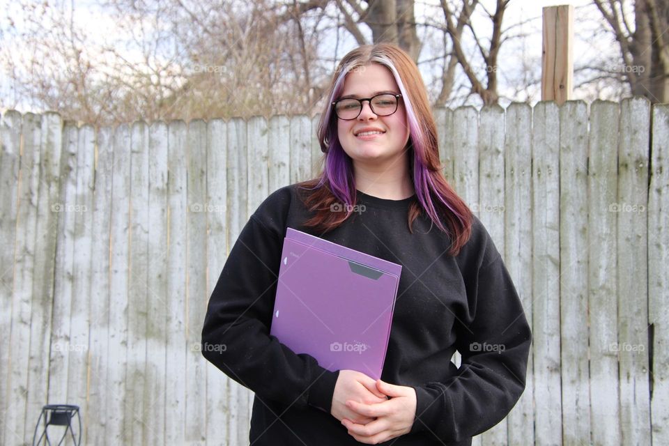 Teenager student with purple five star folder 