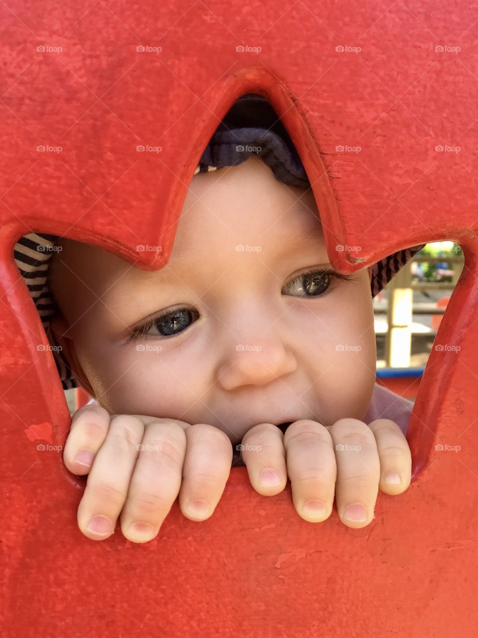 Little boy looks through a red crown 