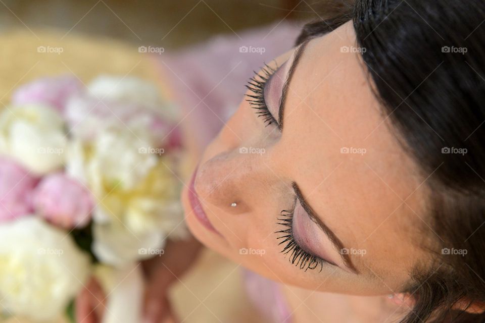 Young bride doing her make up before going to church