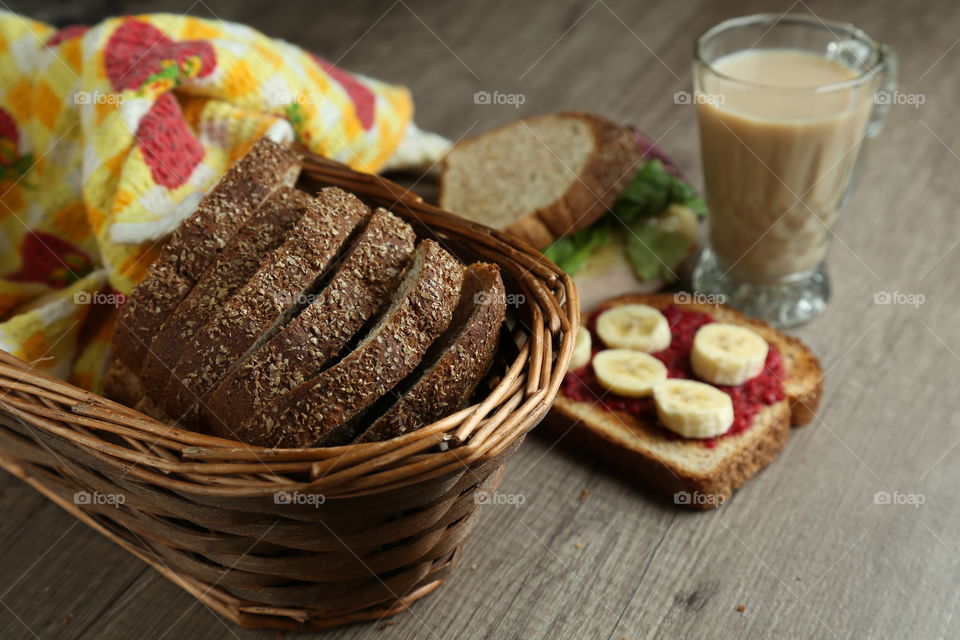bread slices in a basket with sandwiches in the background