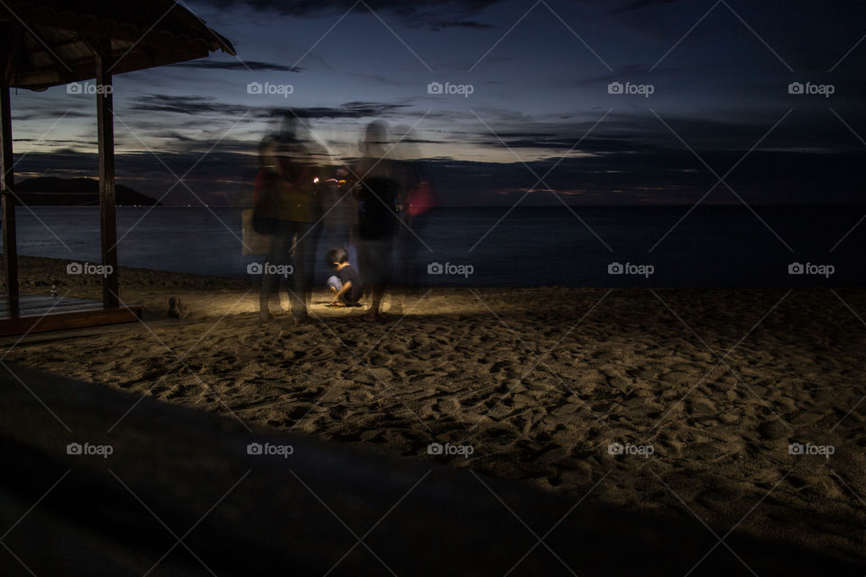 Child playing on sandy beach at night