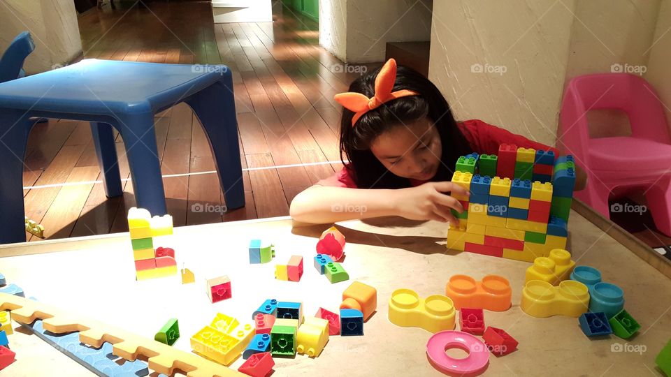 Girl playing wooden toys. Ploy enjoy the kids club
