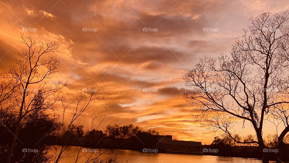 Deep Sunset Colors is upon the Beautiful Sunset also sky reflections silhouetted across colorful Lake waters. 