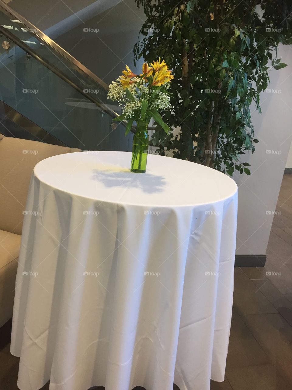 White cocktail round high top table decorated with flowers. Fancy. Simple