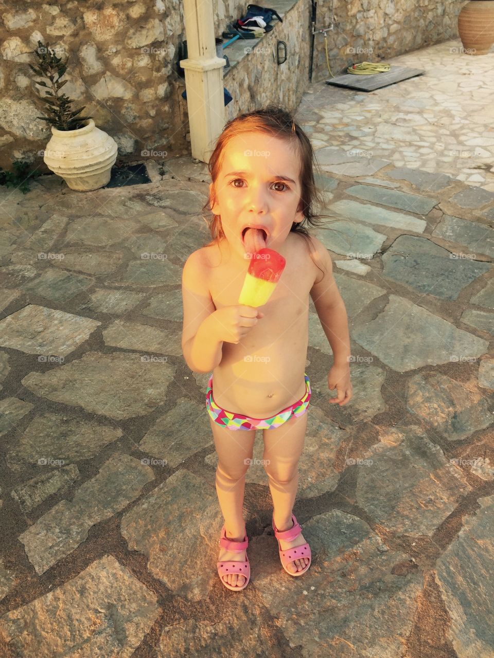 Topless girl eating ice cream candy