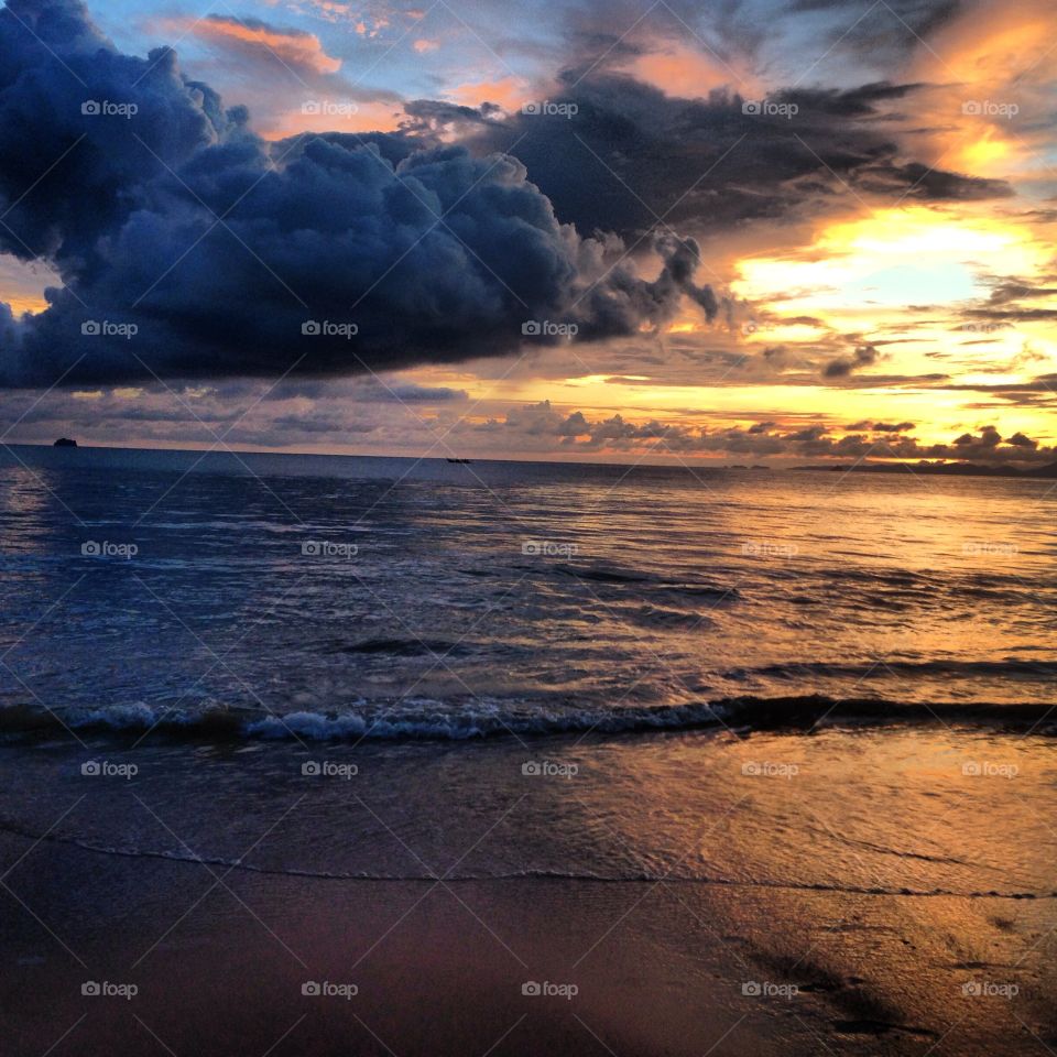 Storm cloud over beach at sunset