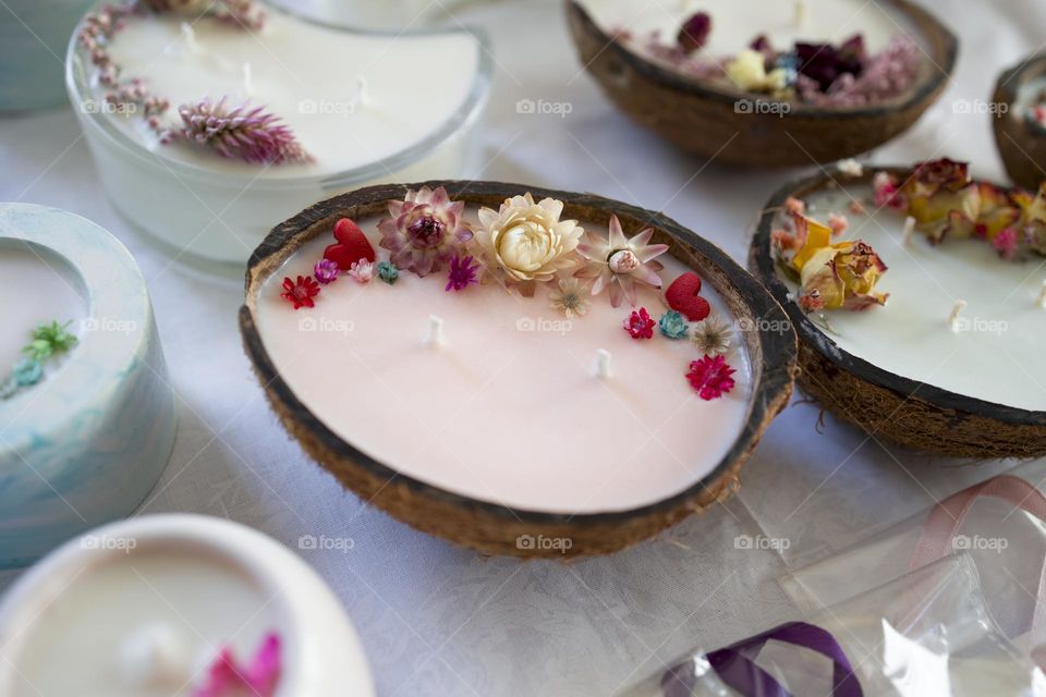 Handmade coconut aromatic candle decorated with flowers .