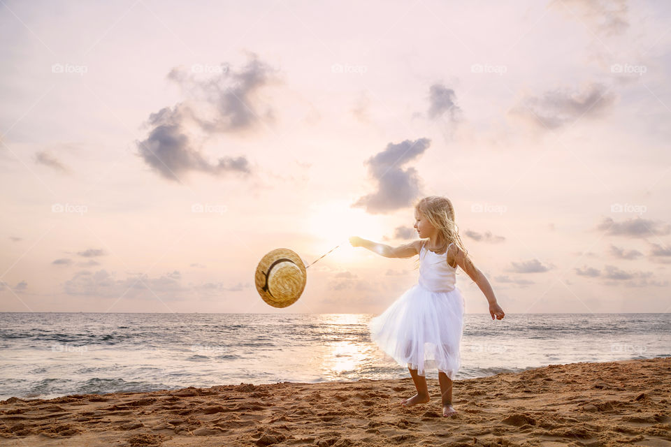 Little girl playing on the beach 