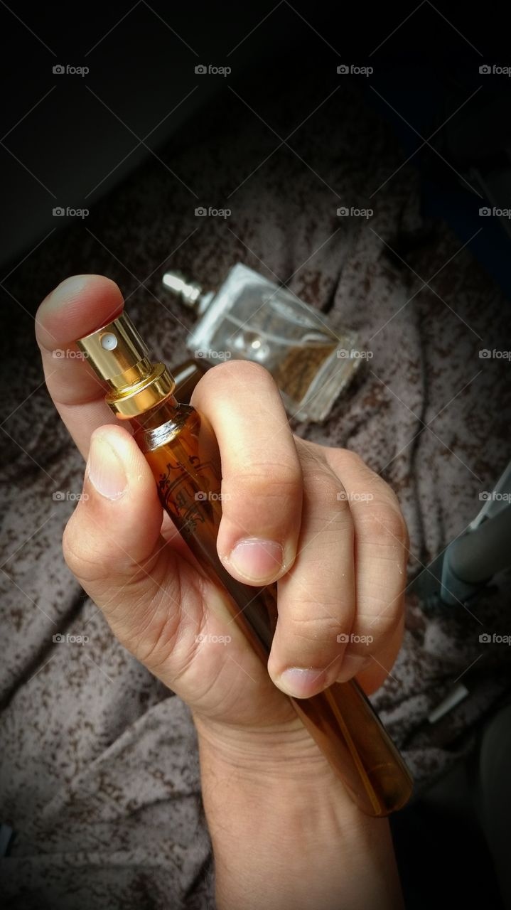 Frasco de vidro na mão. Ação spray essência perfume.