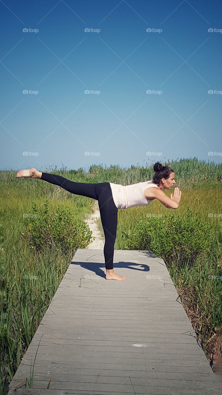 Woman doing yoga on pier
