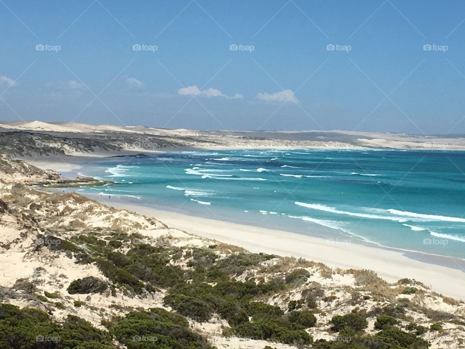 Sand dunes flank his gorgeous view of the turquoise blue coastline of south Australia near Coffin Bay, on a gorgeous clear blue day 