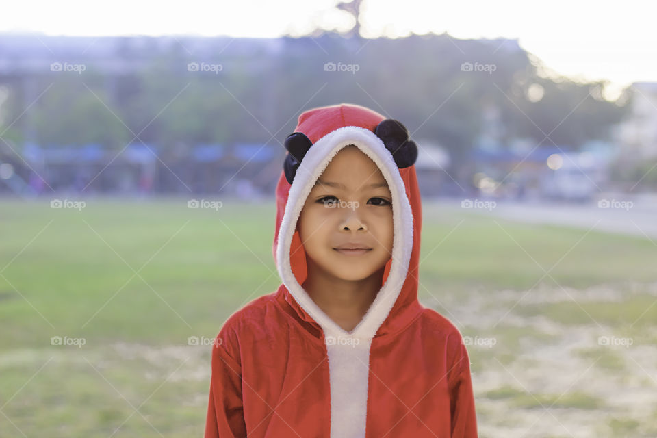 Asia boy wearing a red Christmas Background on the school lawn.