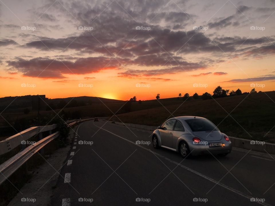 Car driving into the sunset on the highway