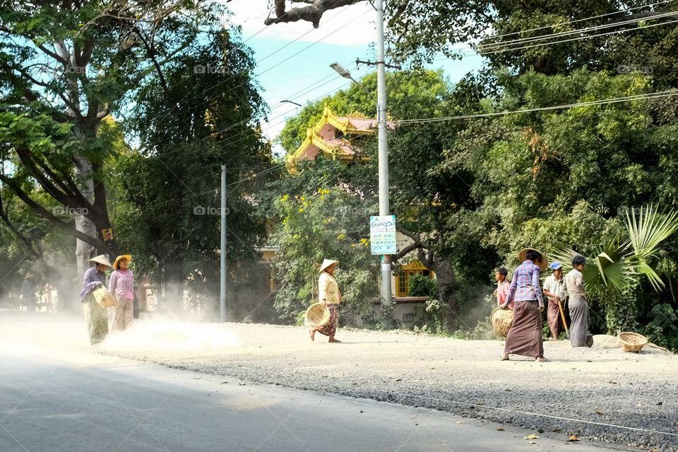 Women working to finish cementing the road