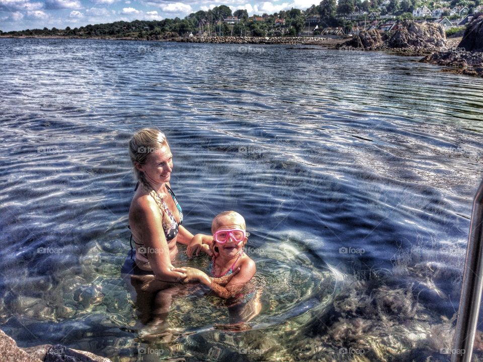 Mother and daughter. Learning to swim