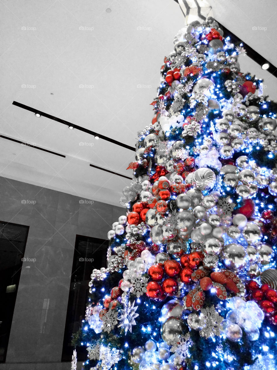 a christmas tree with red and silver christmas balls and wrapped in blue light
