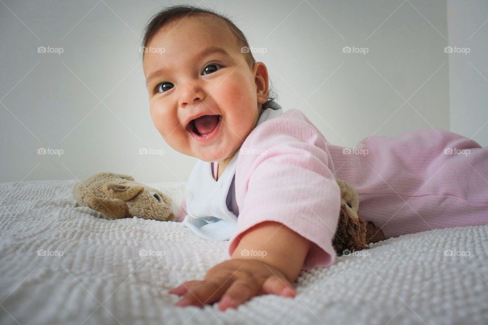 Happy baby girl is reaching for the camera