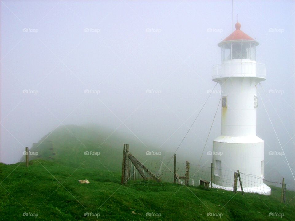 Lighthouse in heavy fog. 
Mykines, Faroe Islands.