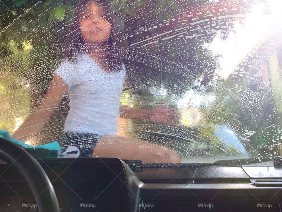 little girl washing grandpa's car