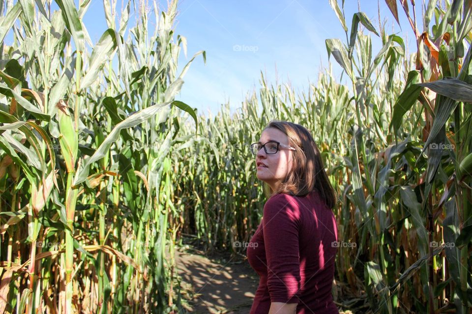 Young woman exploring a corn field maze