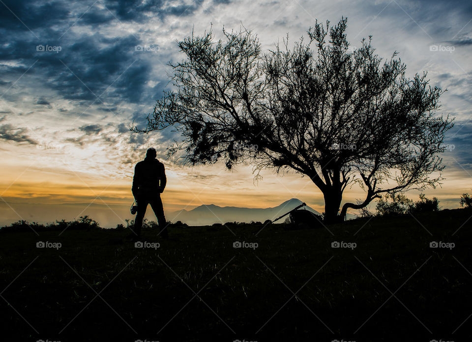 Silhouette of a man looking at the mountains