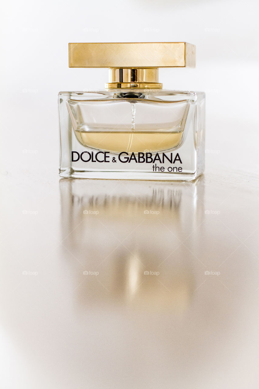 Close up image of perfume on a reflective surface. Love the details you can see on the bottle surface.