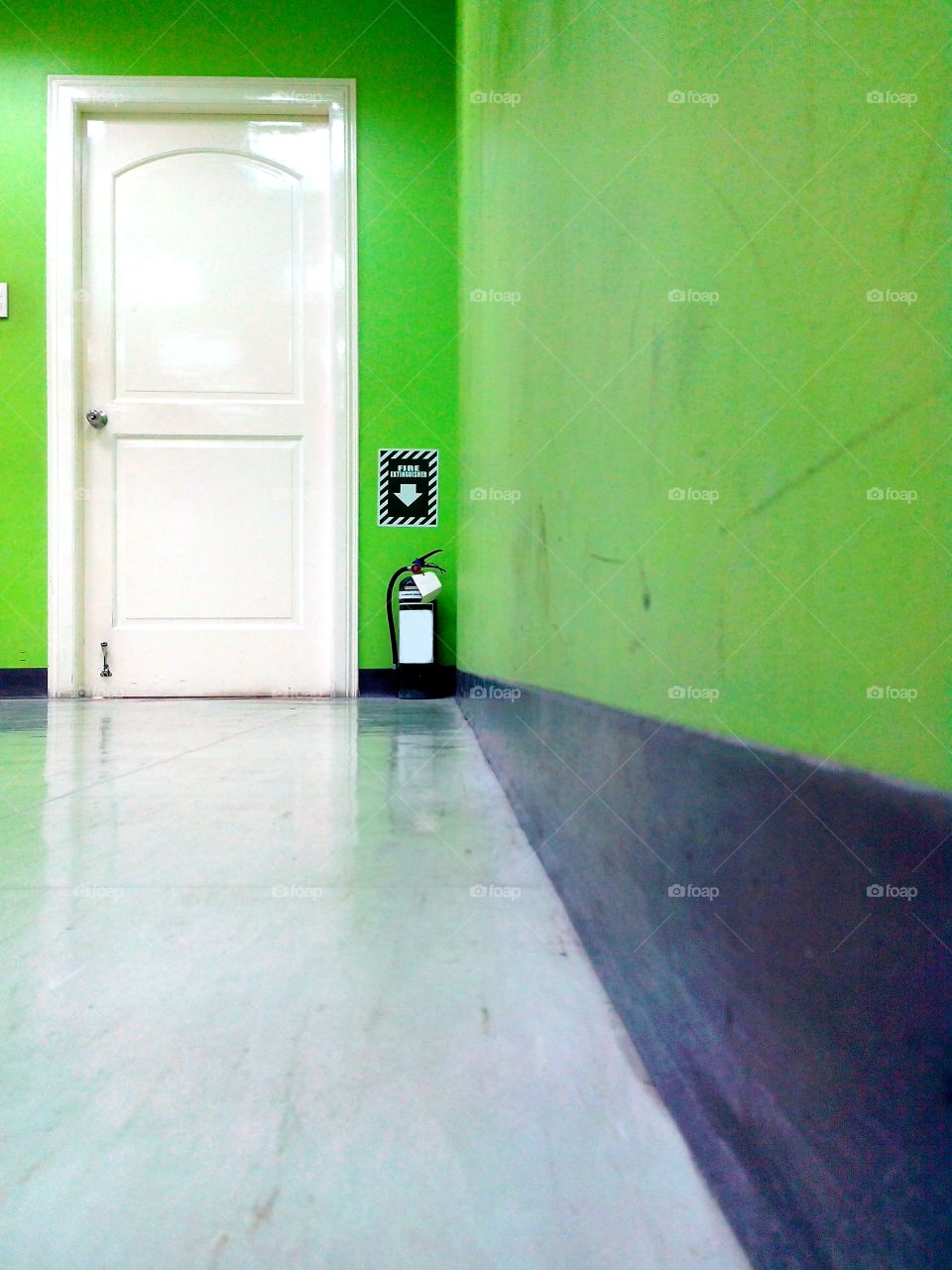green wall, white door. white door in a room with green wall and a fire extinguisher