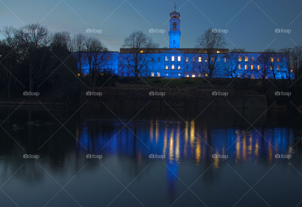 The Trent building from highfeilds boating lake creating, bathed in blue light.