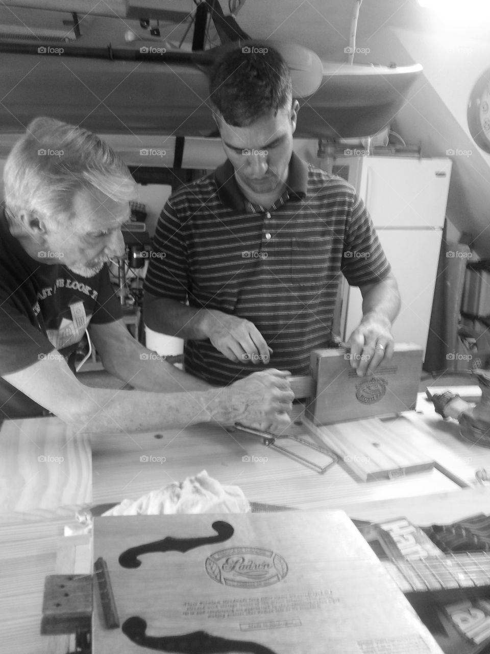 Son and dad working on a cigar box guitar together and dad was showing our son how to build one.