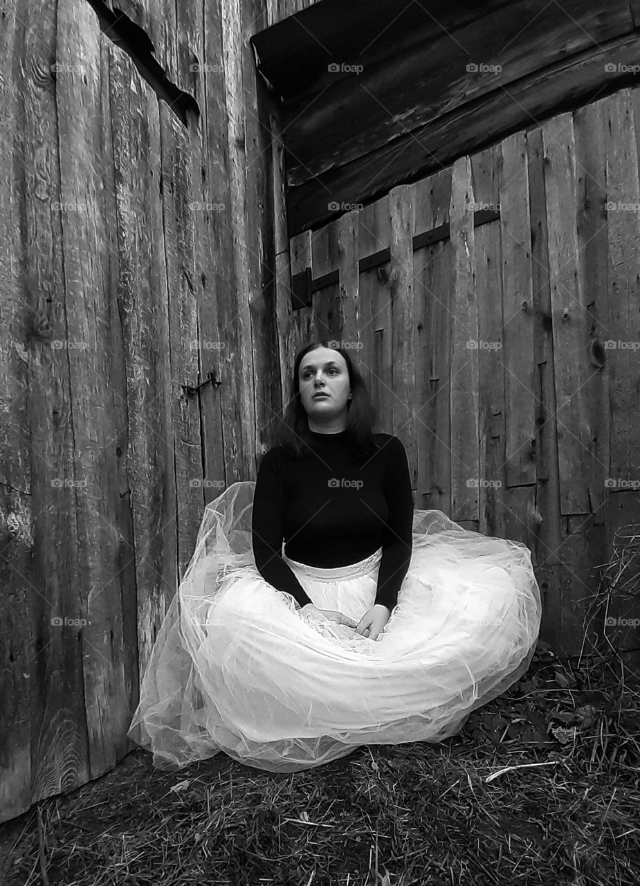 Black and white photo of a sad girl in a dress
