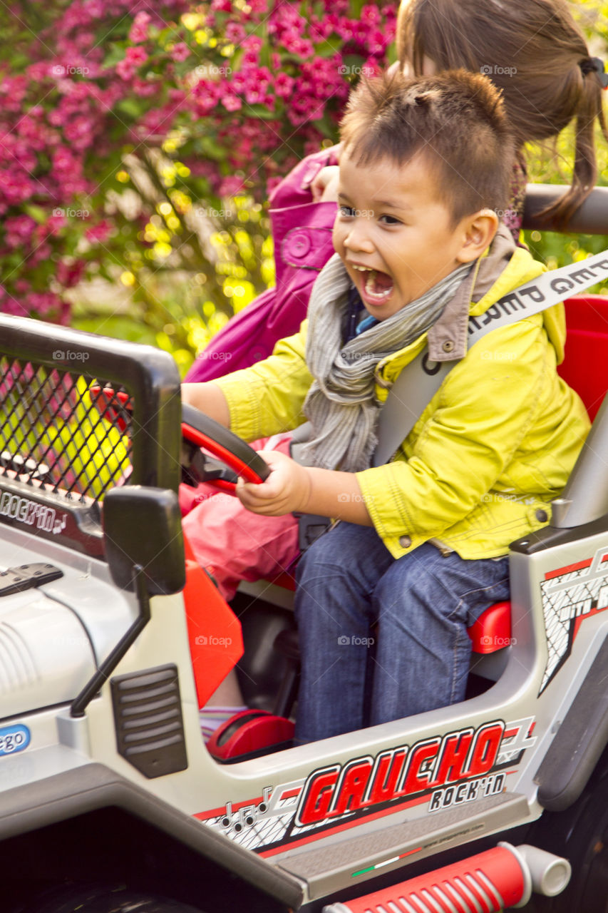 Kids enjoying spring. Thitiwin happy driving in the garden