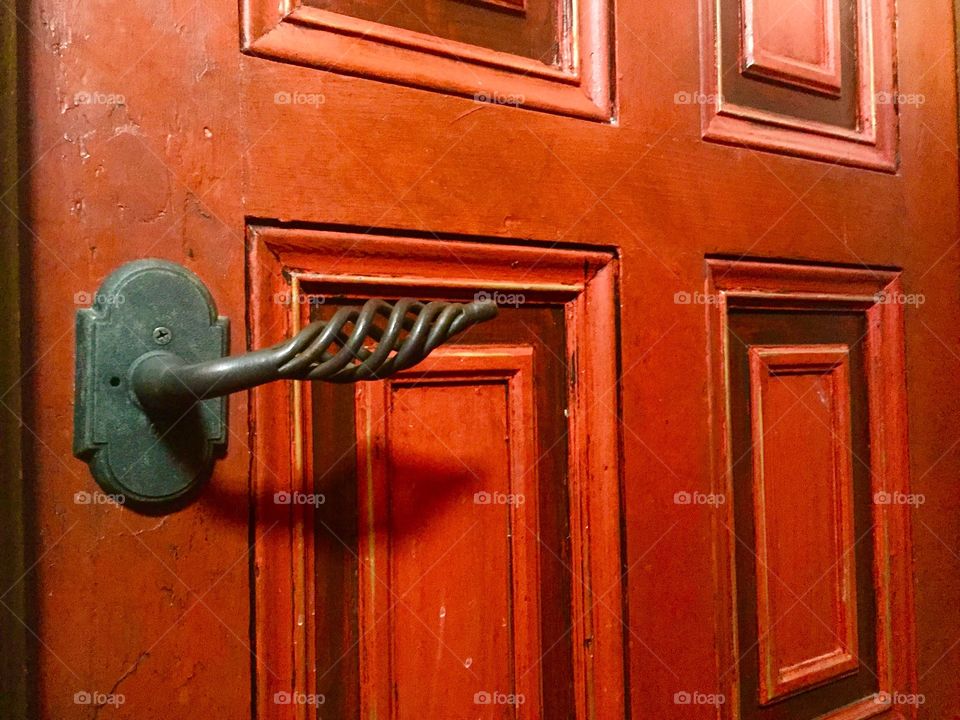 Antique red door with decorative door knob