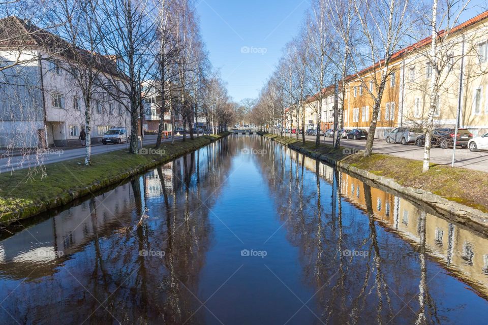 Beautiful peaceful kanal with calm water and reflection between the houses in the city of Alingsas Sweden on a sunny day with blue sky