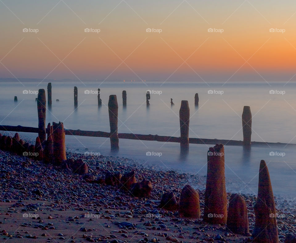 Just before dawn on the beach at Winchelsea, the misty water creates an ethereal look around the old wooden groynes