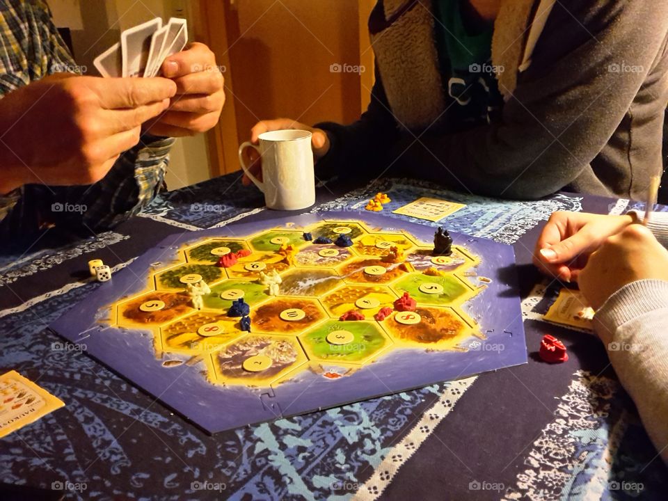playing the bar boar game 'settlers of catan'